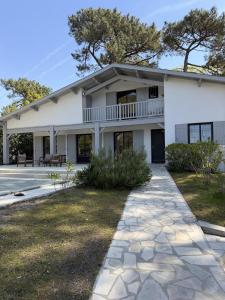 a white building with a walkway in front of it at Bask'aise o Pyla in La Teste-de-Buch