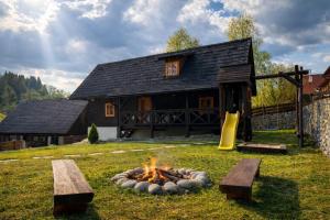 a fire pit in a yard in front of a house at Traditional deer Cabin with Sauna - Chata Srňacie in Dolný Kubín
