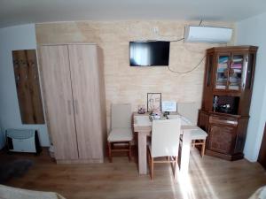 a dining room with a white table and chairs at Zlatna Vila in Kanjiža