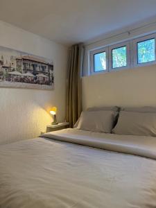 a bedroom with a white bed with two windows at Perla Sea View in Budva