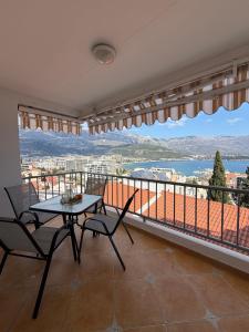 a table and chairs on a balcony with a view at Perla Sea View in Budva