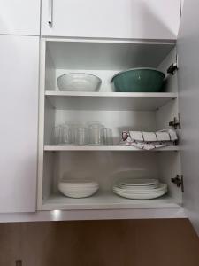 a white cabinet with plates and bowls in it at Apartman Park in Stara Pazova +23 photos
