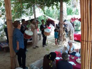 a group of people playing drums in a tent at La tente tamaghza in Tamaghzah