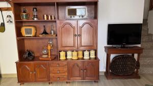 a large wooden entertainment center with a tv on top at Cominhos & Quartilhos in Sortelha