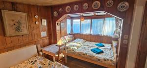 a bedroom with two beds and a table and a chair at Chata u Hřiště in Loučeň