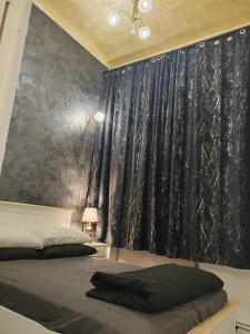 a bedroom with a bed and a black curtain at Baroque Palace Black Diamond in Arad
