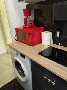 a red microwave sitting on top of a kitchen counter at Baroque Palace Black Diamond in Arad