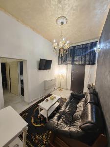 a living room with a leather couch and a table at Baroque Palace Black Diamond in Arad