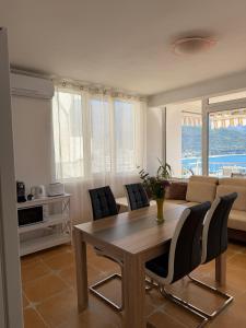 a living room with a table and chairs and a couch at Perla Sea View in Budva