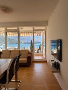 a living room with a couch and a view of the ocean at Perla Sea View in Budva