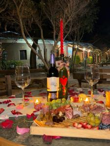 a table with a bottle of wine and two glasses at Hotel SPA Campestre Los Adobes in Taxco de Alarcón