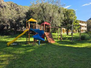 a playground with a slide in the grass at Condominio La Curva in Churín