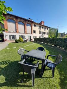 a table and chairs in the grass in front of a building at Cascina San Giulio in San Damiano dʼAsti