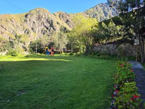 a green yard with a playground and mountains in the background at Condominio La Curva in Churín