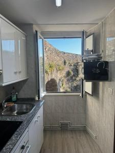 a kitchen with a view of a mountain from a window at PASEO CASCO ANTIGUo in Lugo