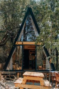 a frame cabin in the woods with a picnic table at WANDER CABIN La Marquesa in La Marquesa
