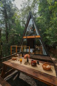 a house with a wooden table in the woods at WANDER CABIN La Marquesa in La Marquesa