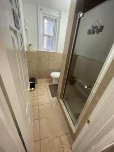 a bathroom with a toilet and a glass shower door at TORONTO UNIVERSITY PRIVATE ROOM-Next to Eaton Centre in Toronto