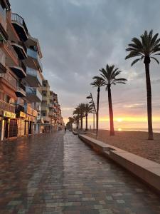 a cobblestone street with palm trees on a beach at Comfort home Calafell in Calafell