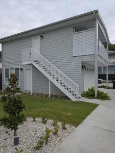 a gray house with a white staircase on it at Serenity Valley Brooklyn in Brooklyn