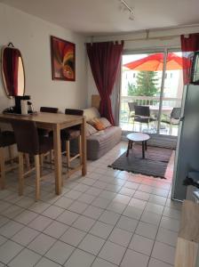 a living room with a table and a couch at Le Thalassa I appartement T2 en bord de plage et du Port in Gruissan