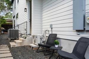 a pair of chairs sitting outside of a house at Modern Downtown Apt Fast Wi-Fi & Parking in Austin