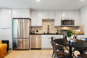 a kitchen with white cabinets and stainless steel appliances at Modern Downtown Apt Fast Wi-Fi & Parking in Austin