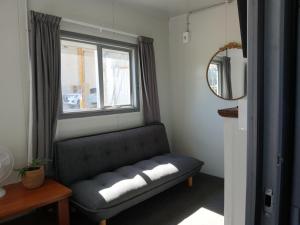 a living room with a couch and a window at Harbour Heights Cabins in Athenree