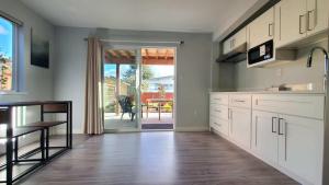 a kitchen with white cabinets and a wooden floor at Meet Cottage in Vancouver