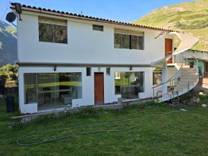 a white house with a yard with a hose at Condominio La Curva in Churín +41 photos