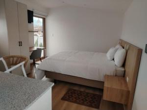 a small bedroom with a bed and a table at Art Deco 882 in Cuenca