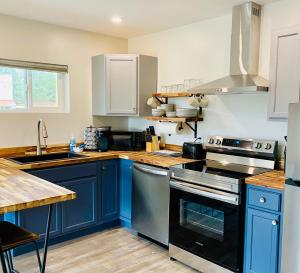 a kitchen with blue cabinets and a stove top oven at The Darmont Hotel and Suites in Darby