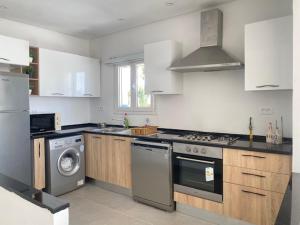 a kitchen with a stove and a washing machine at Panoramic 2 bedrooms Ennassr in Ariana