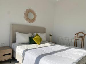 a bedroom with a large bed with a yellow pillow at Panoramic 2 bedrooms Ennassr in Ariana