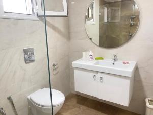 a bathroom with a toilet and a sink and a mirror at Panoramic 2 bedrooms Ennassr in Ariana
