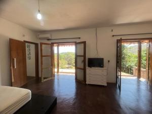 a bedroom with a bed and a tv on a dresser at rancho california rancho beira d'água Delfinopolis in Delfinópolis