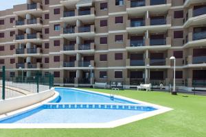 an apartment building with a swimming pool in front of it at Marina suite in Peniscola