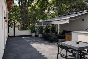 a patio with chairs and tables and a tree at Casa Lerma in Mexico City