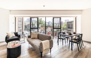 a living room with a couch and a table with a view at Kukun Reforma & Downtown in Mexico City