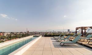 a row of lounge chairs on the roof of a building at Kukun Reforma & Downtown in Mexico City