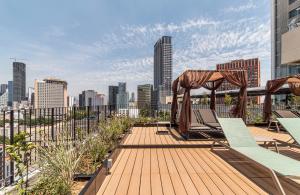 a deck with chairs and a gazebo on a city skyline at Kukun Reforma & Downtown in Mexico City +28 photos