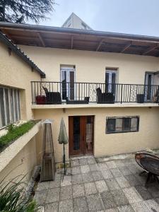a house with a patio and a balcony with chairs at 15 min Paris in Drancy
