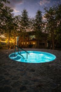 a small blue pool in a yard at night at Hotel Termaland in Atiquizaya