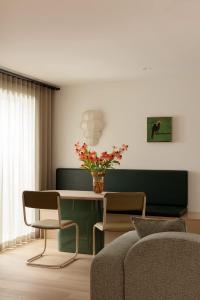 a living room with a table with a vase of flowers at Bon Bon Apt 1 - Papi in Orange