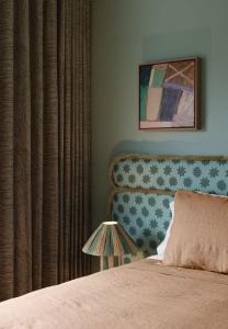a bedroom with a bed and a curtain and a lamp at Bon Bon Apt 1 - Papi in Orange