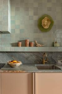 a kitchen counter with a sink and a bowl of oranges at Bon Bon Apt 1 - Papi in Orange