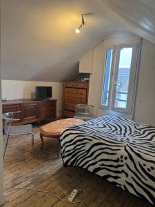 a bedroom with a zebra print bed and a window at 15 min Paris in Drancy