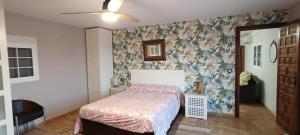 a bedroom with a bed with a floral wallpaper at Finca San Diego, villa entera para ti in Vallonga +43 photos