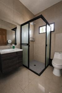 a bathroom with a shower with a toilet and a sink at Hotel Termaland in Atiquizaya