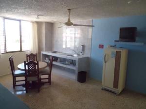 eine Küche mit Tisch, Spüle und Kühlschrank in der Unterkunft Suites Angelopolis in Acapulco
